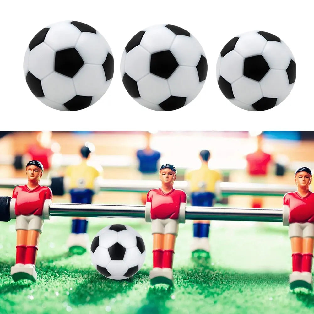 Set of three classic black and white footballs shown on a green table football pitch with player figurines.