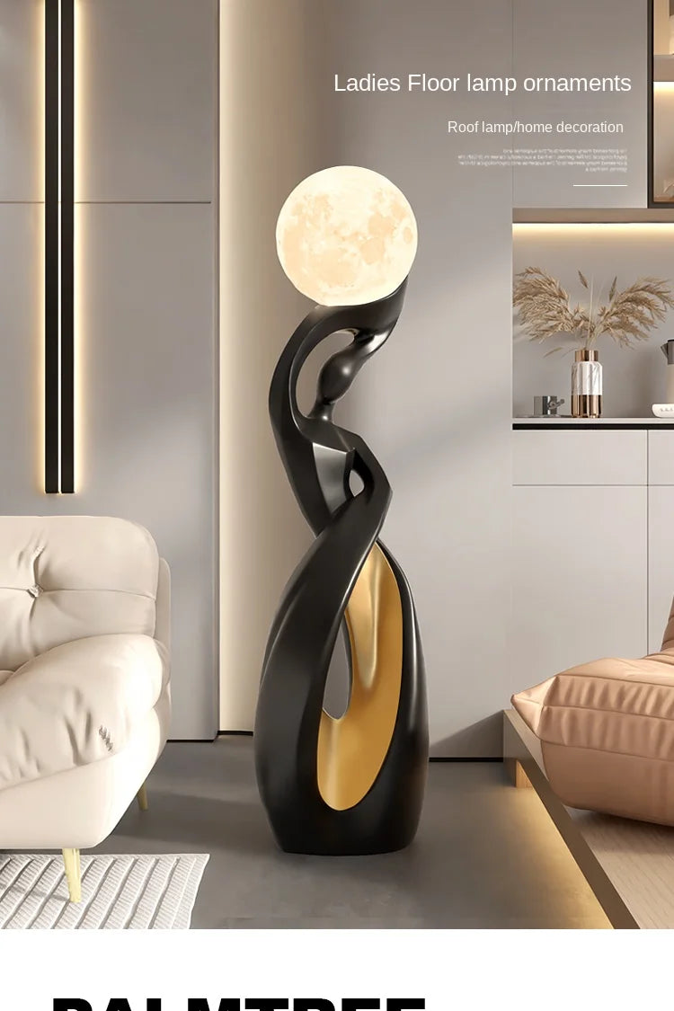 Abstract black resin floor statue featuring a glowing moon-like spherical lamp and elegant gold interior detail.