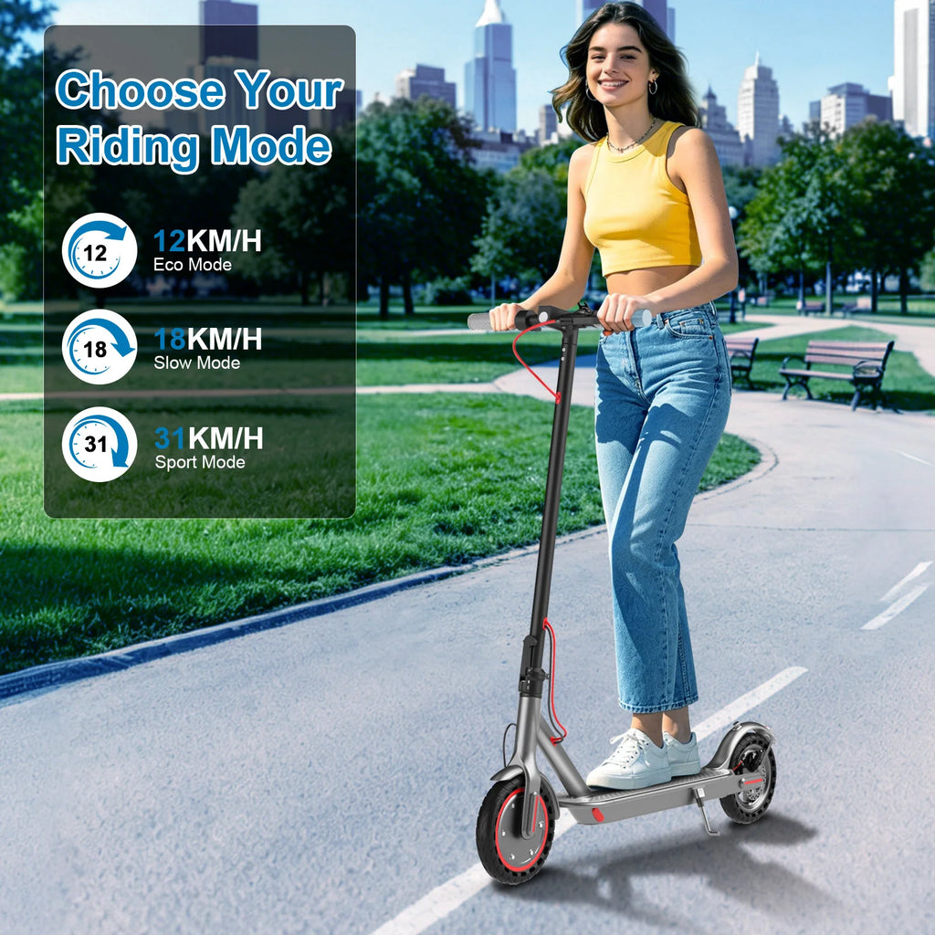 Gray AOVOPRO foldable adult electric scooter with 8.5-inch tires being ridden outdoors on a paved path.