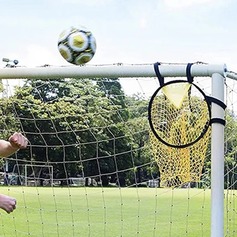 Yellow football target net attached to a goal post corner, with a ball flying toward the goal.