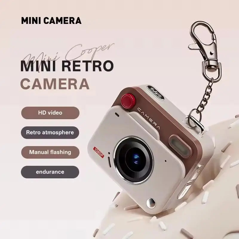 Beige and brown plastic mini digital camera keychain with a metal clasp, featuring an HD lens and manual flash.