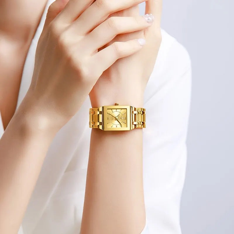 Minimalist gold-tone stainless steel quartz watch with a sleek square face and matching link bracelet on a wrist.