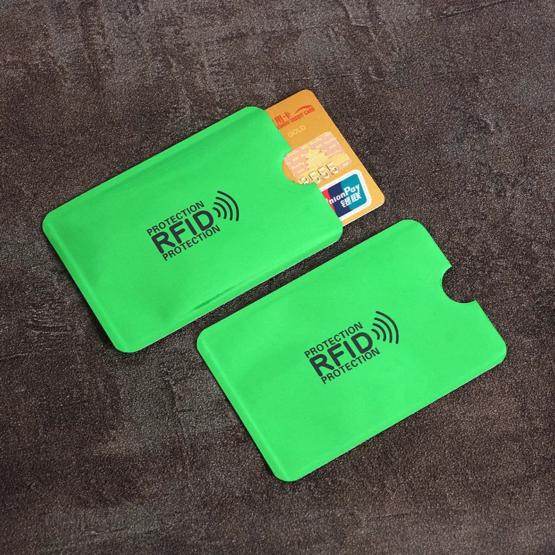 Two lime green RFID-blocking card sleeves made of thin, smooth material, one holding a gold credit card.