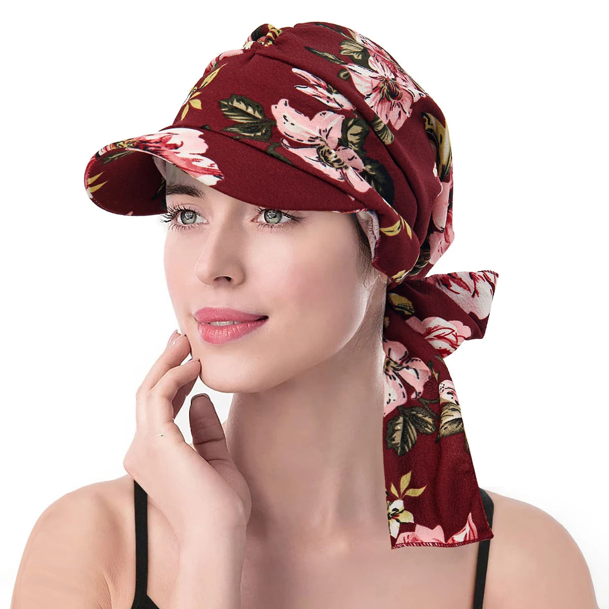Burgundy floral print vintage-style turban hat with a structured brim and a tie-back detail, worn by a woman.