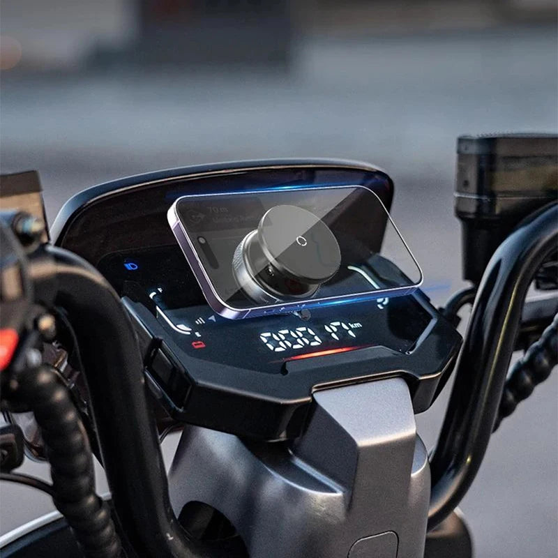 A black magnetic smartphone mount attached to a motorcycle digital dashboard display.