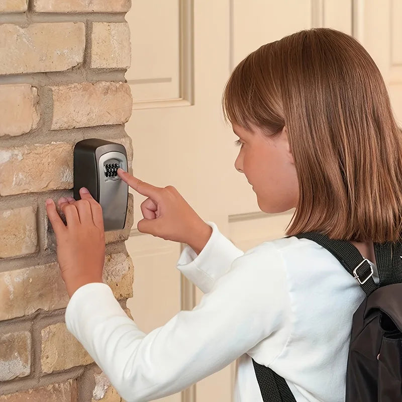 A girl touches a grey metal wall-mounted key storage lock box with a push-button combination code pad.