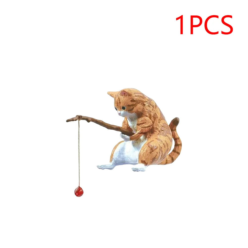 Cute orange tabby cat aquarium ornament holding a wooden fishing rod with a red bauble lure.
