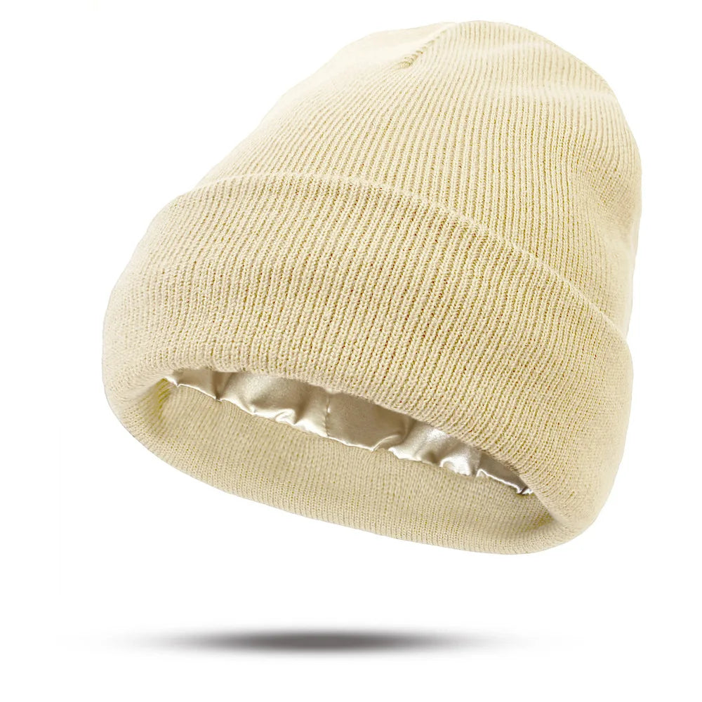 Cream knitted beanie hat with a turn-up cuff and a smooth, luxurious satin lining.