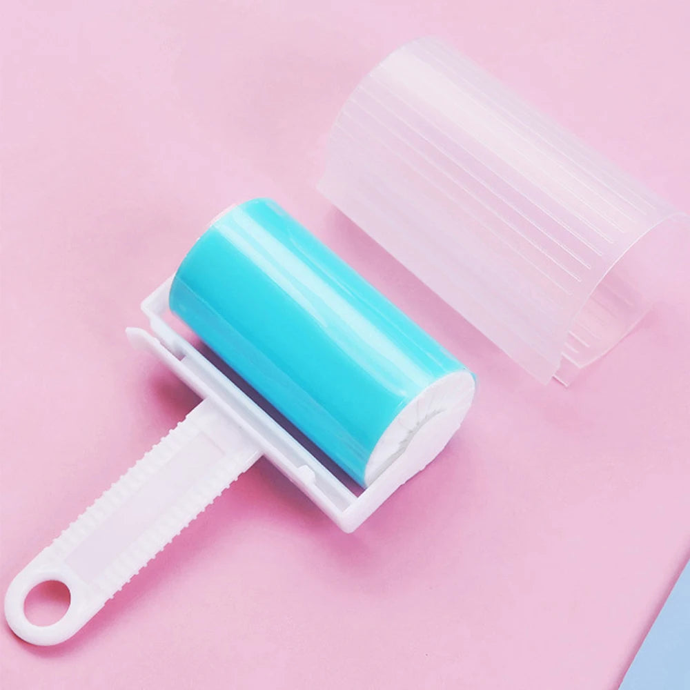 Bright blue reusable lint roller with a white handle and translucent protective cover on a pink background.