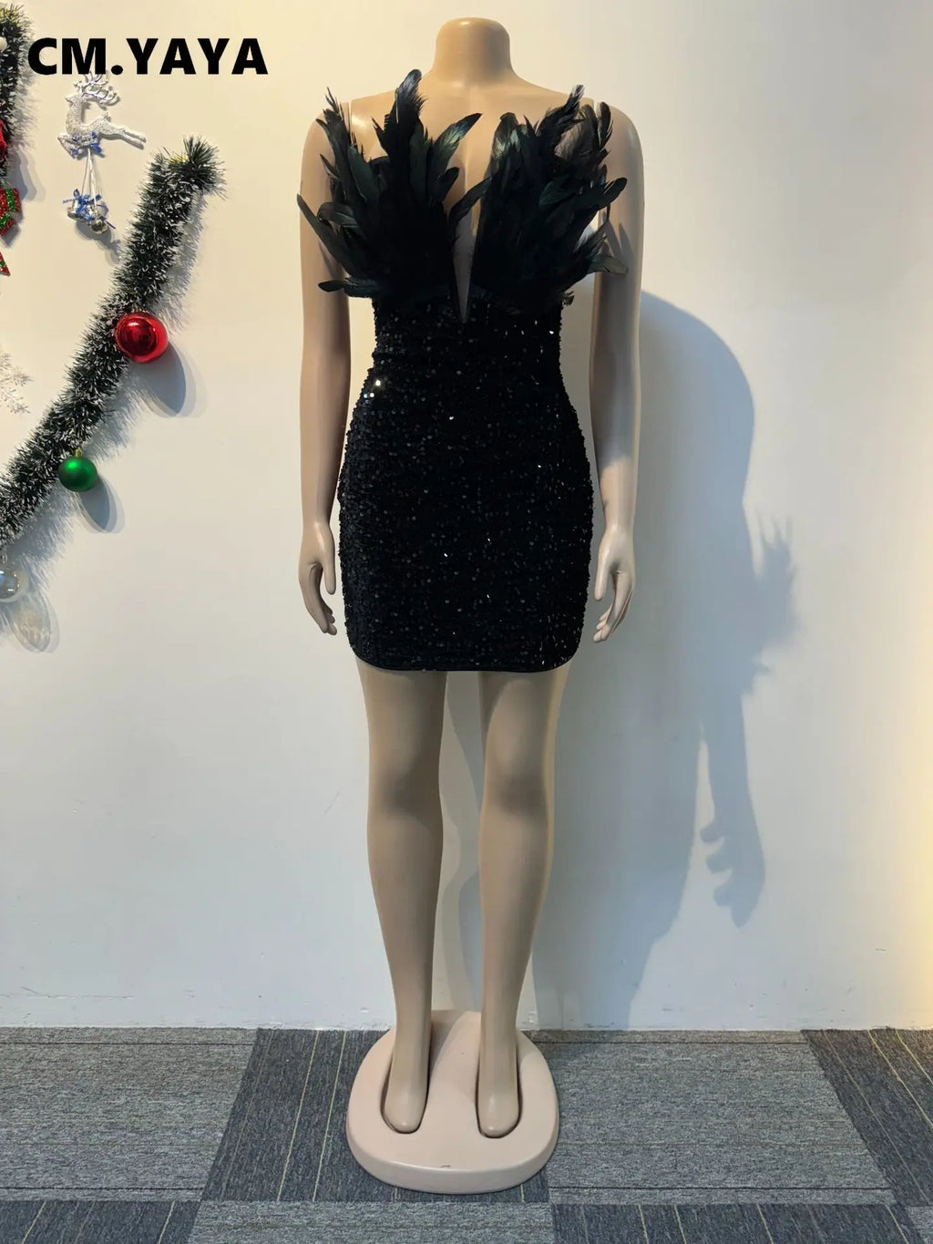 Black sequin bodycon mini dress with plunging V-neck and feathered straps on a mannequin.