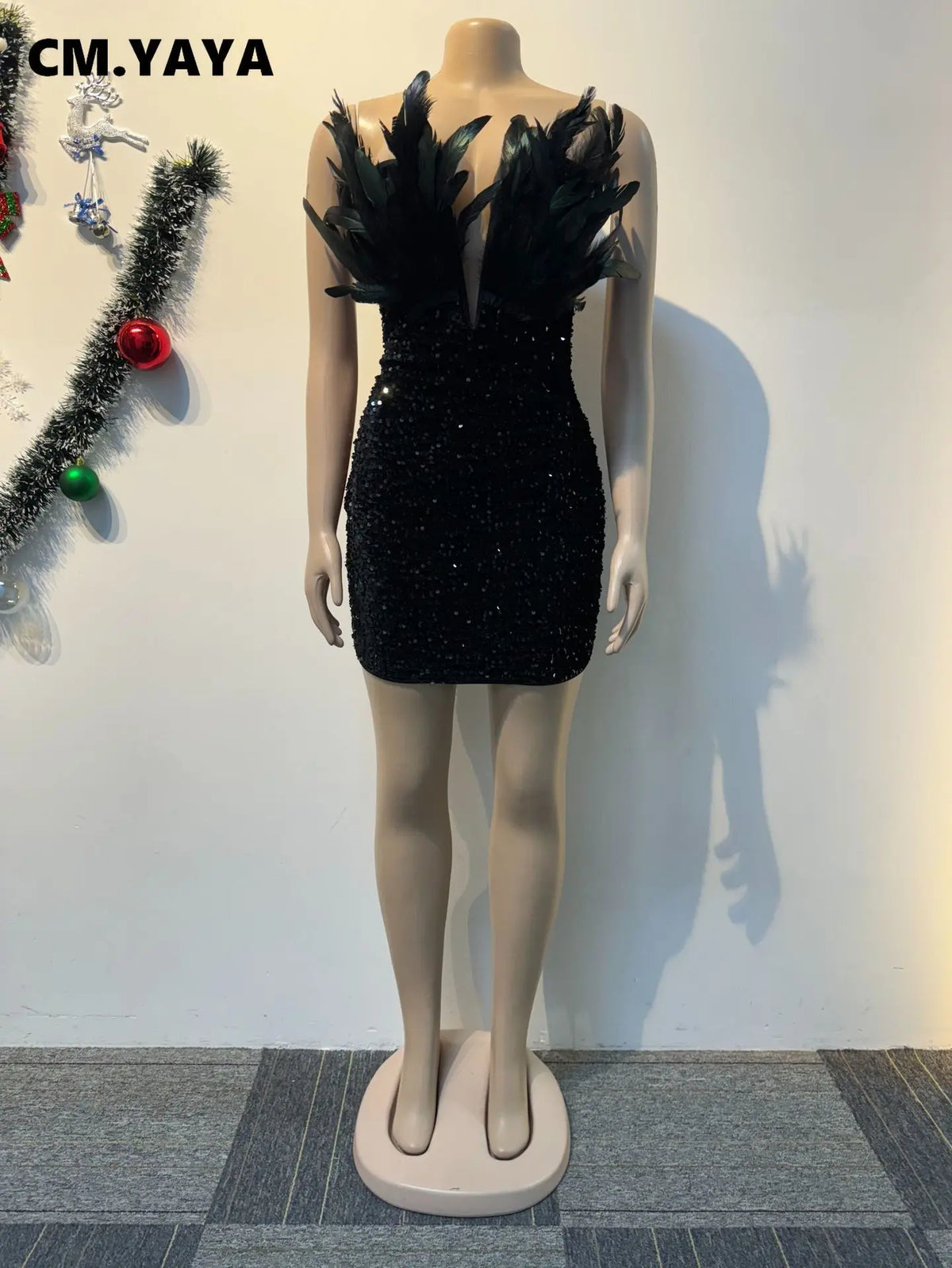 Black sequin bodycon mini dress with plunging V-neck and feathered straps on a mannequin.