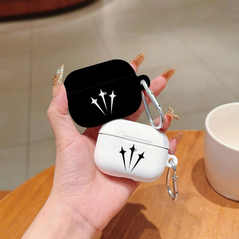 Black and white silicone AirPods Pro cases with star design and metal carabiner clips, held in hand.