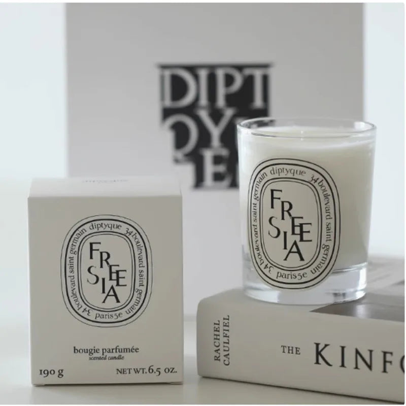 Freesia-scented white candle in a clear glass jar with a matching white box, displayed on a minimal background.