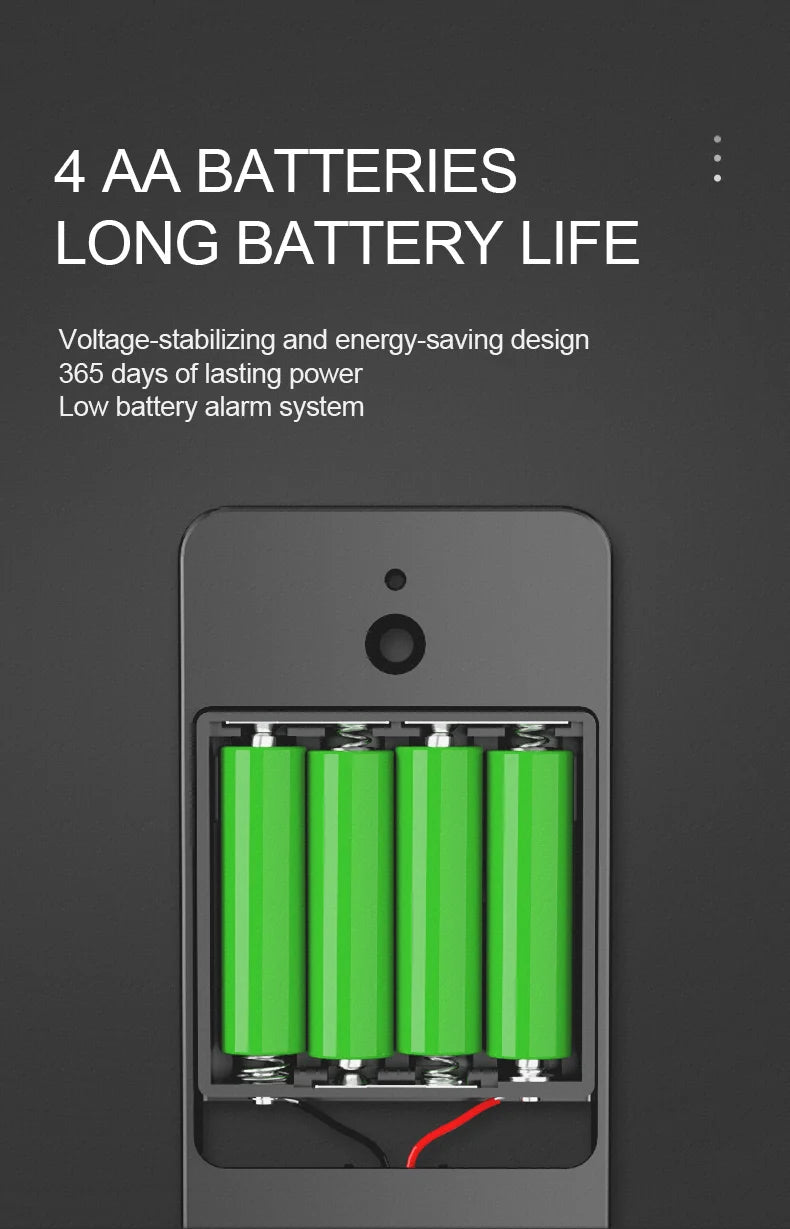 Four bright green AA batteries inside the plastic battery compartment of a dark gray electronic device.