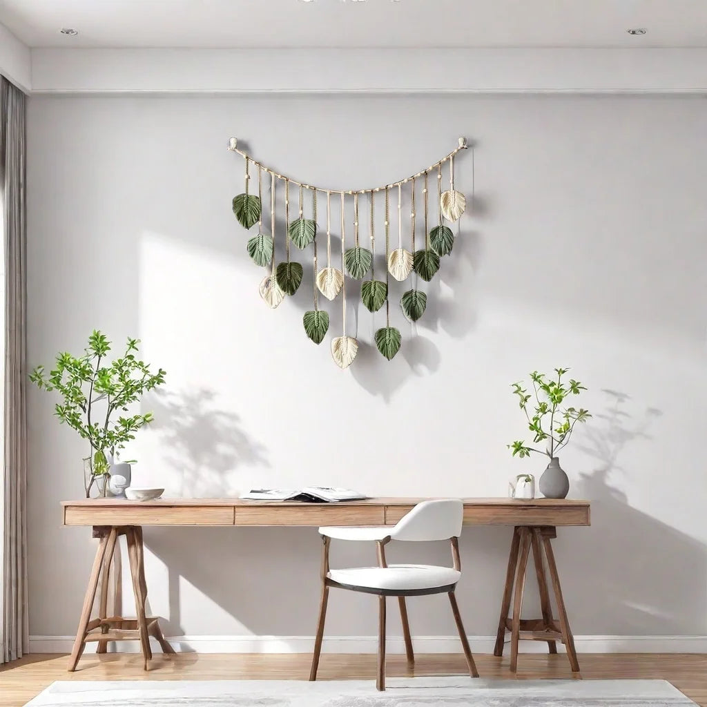 Boho macrame wall hanging featuring sage green and cream leaf-shaped tassels suspended from a curved wooden rod.