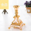 Gold and pink metal candle holder with ornate flourishes and a wide, footed base.