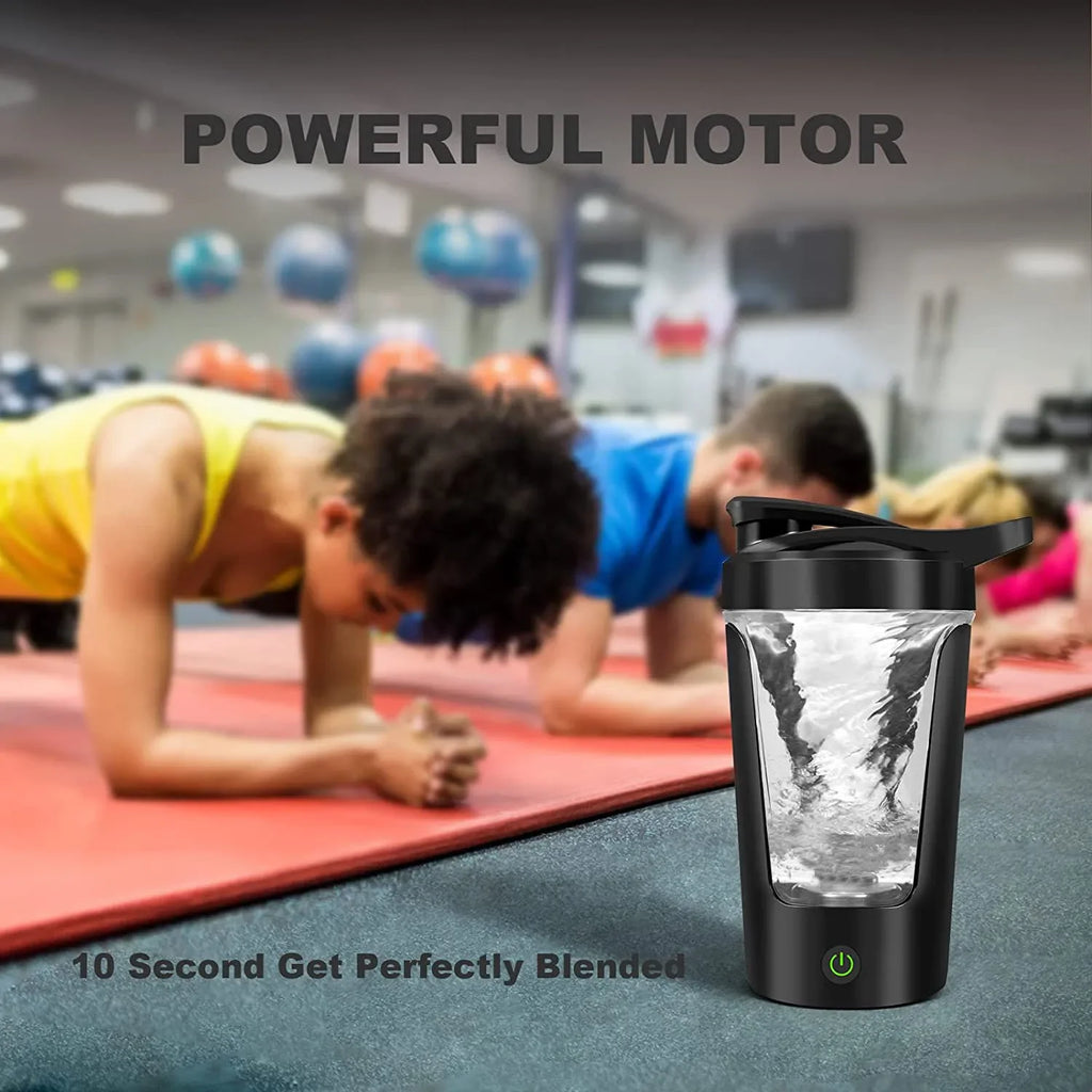 Portable black electric shaker bottle with a vortex blending motor, shown in a gym setting.