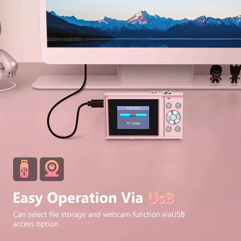 Pink plastic digital camera with a rear LCD screen, connected to a computer via USB cable for storage or webcam use.