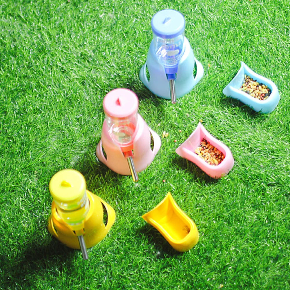 Three sets of colorful pet water dispensers and food bowls in blue, pink, and yellow on artificial green grass.