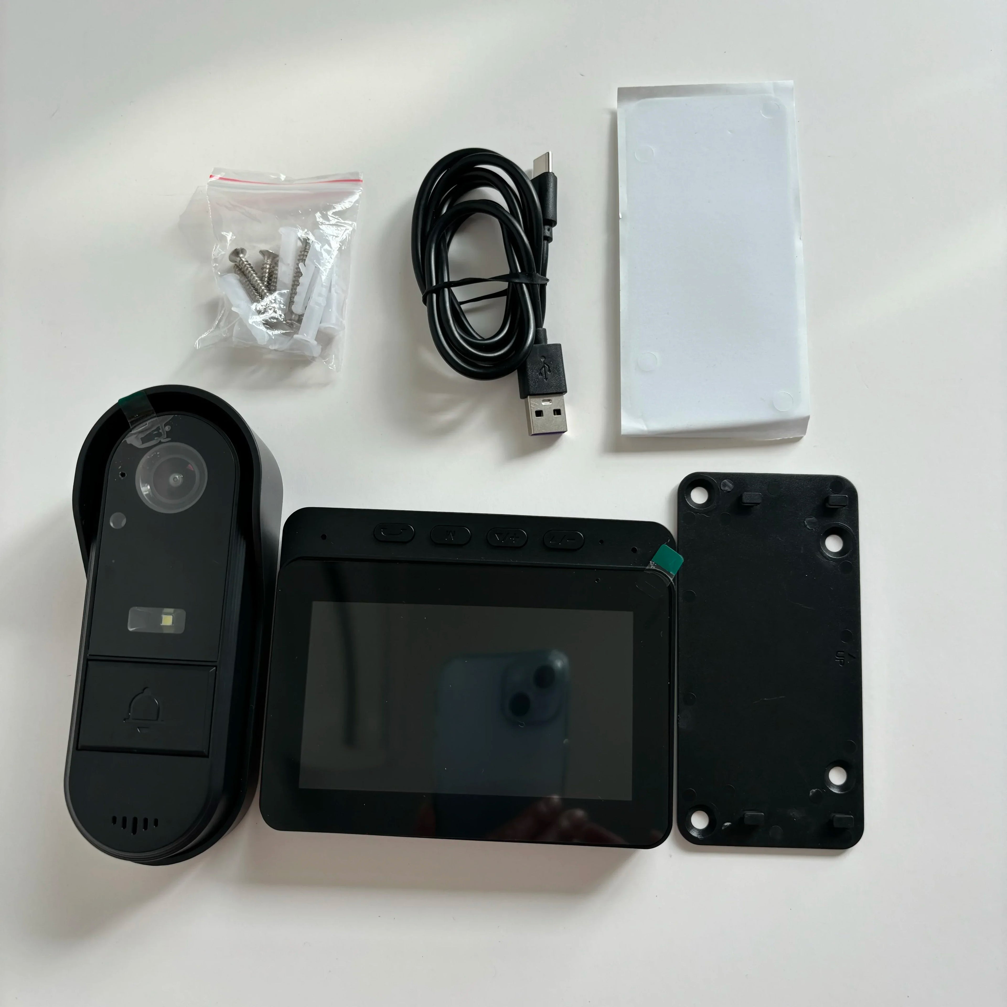 Black wireless video doorbell kit with 4.3in screen, night vision camera, mounting hardware and charging cable.