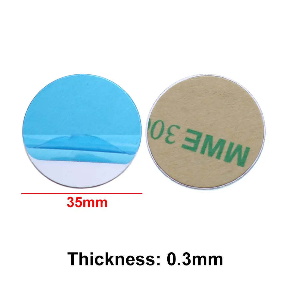Two 35mm round adhesive discs. One shows a blue peel-off tab, the other a tan adhesive backing. Thickness: 0.3mm.