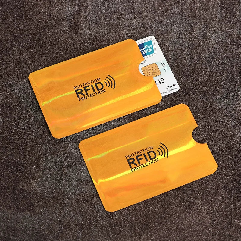 Two orange RFID-blocking plastic sleeves for credit cards, one partially holding a payment card.