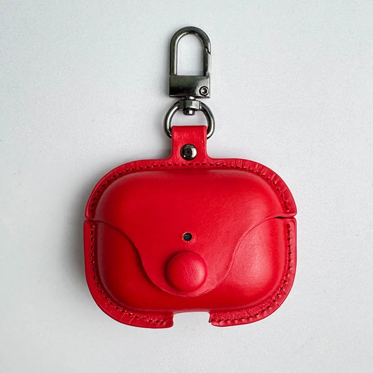 Red leather AirPods Pro case with a press-stud fastening and silver metal carabiner clip.