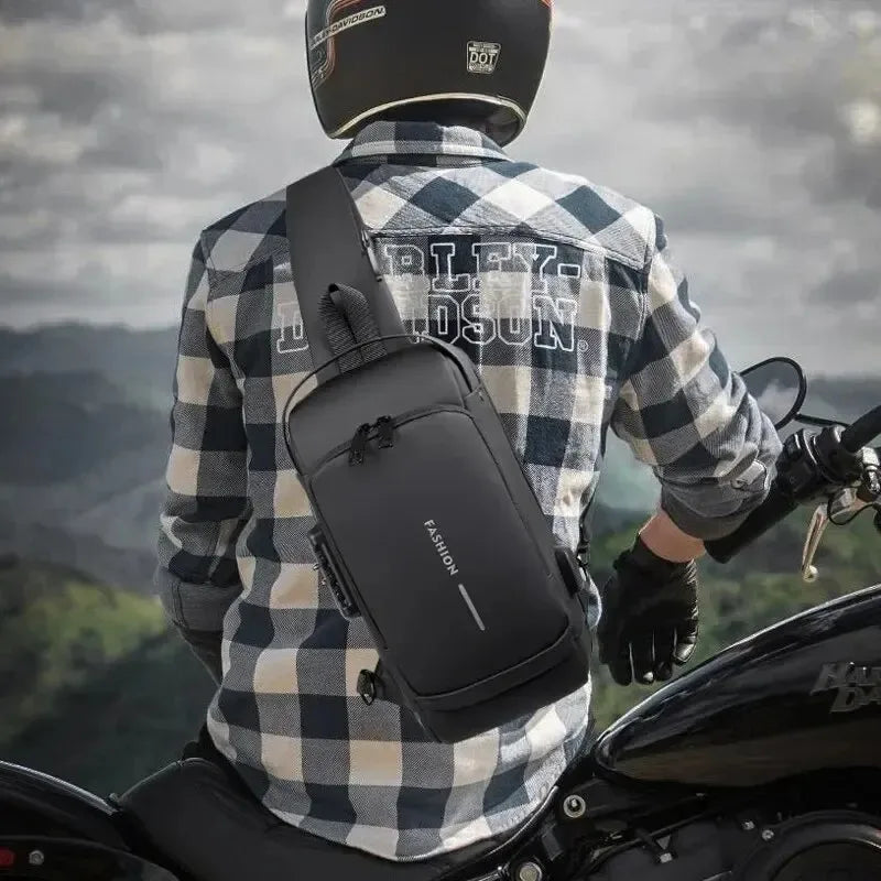 A man on a motorcycle wearing a sleek black, waterproof anti-theft sling bag with a built-in USB charging port.