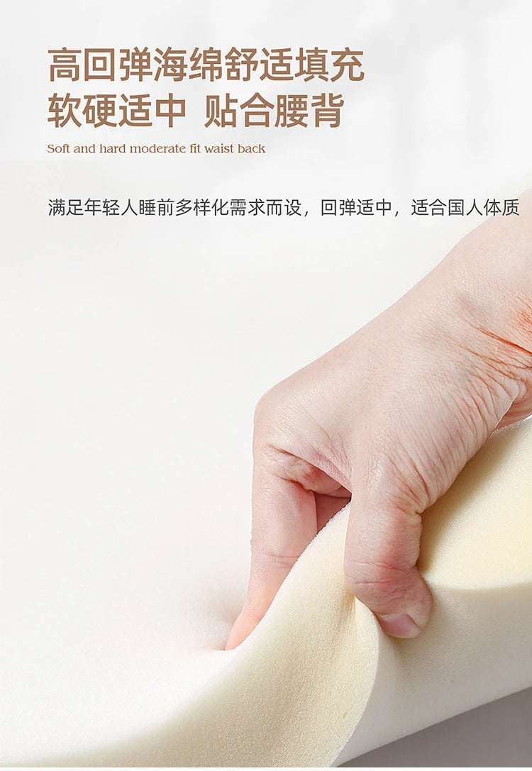 A hand pressing into a piece of soft, cream-coloured high-resilience foam padding for a minimalist bed frame.
