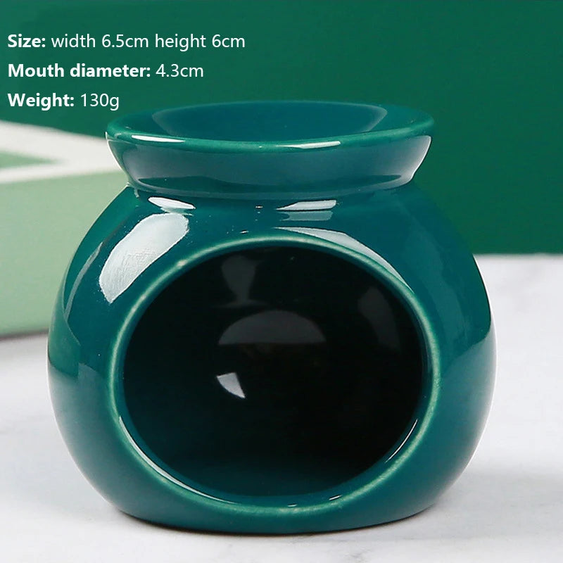 Glossy, dark green ceramic oil burner with a rounded, compact design and wide front opening.