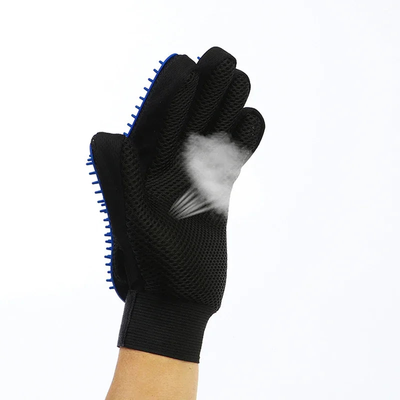 Black mesh pet grooming glove with blue rubber grooming nubs, showing a small cloud of fur being removed.