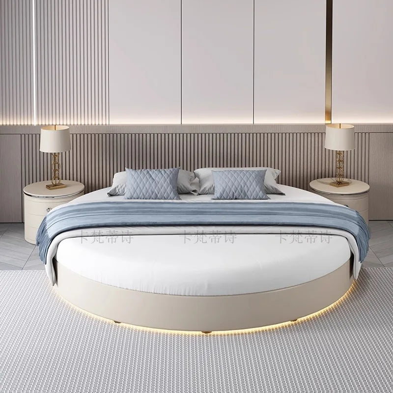 Modern minimalist circular bed frame in cream with integrated under-bed lighting and a grey throw.