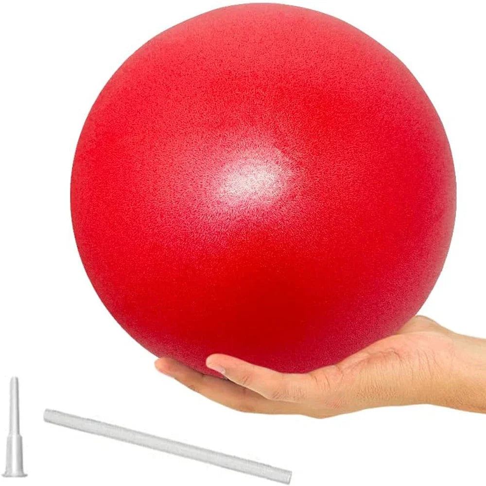 A hand holding a textured red Pilates exercise ball, shown with an inflation straw and nozzle.