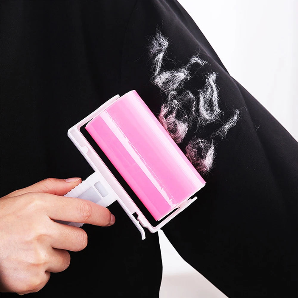 Pink reusable sticky lint roller removing white fluff from a black sleeve.