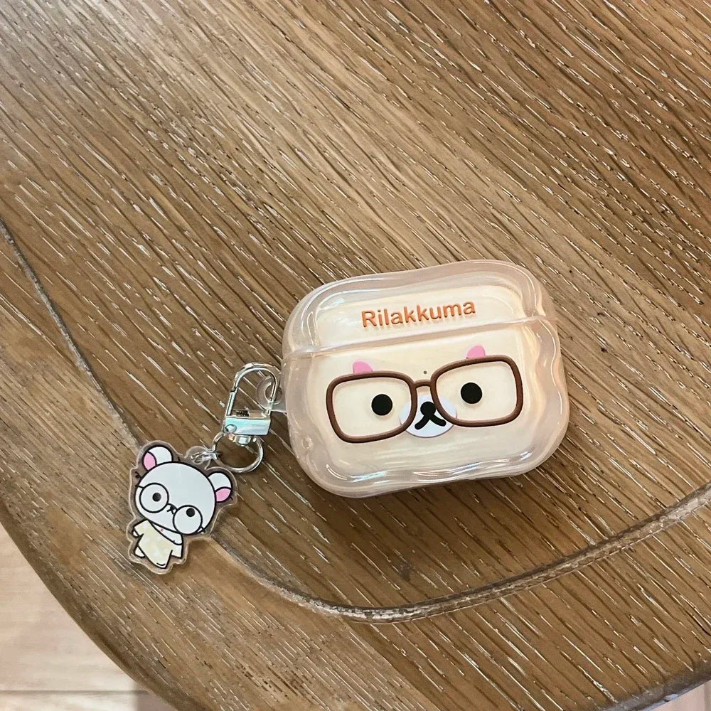 Clear Rilakkuma AirPods Pro case with matching character charm on a wooden table.