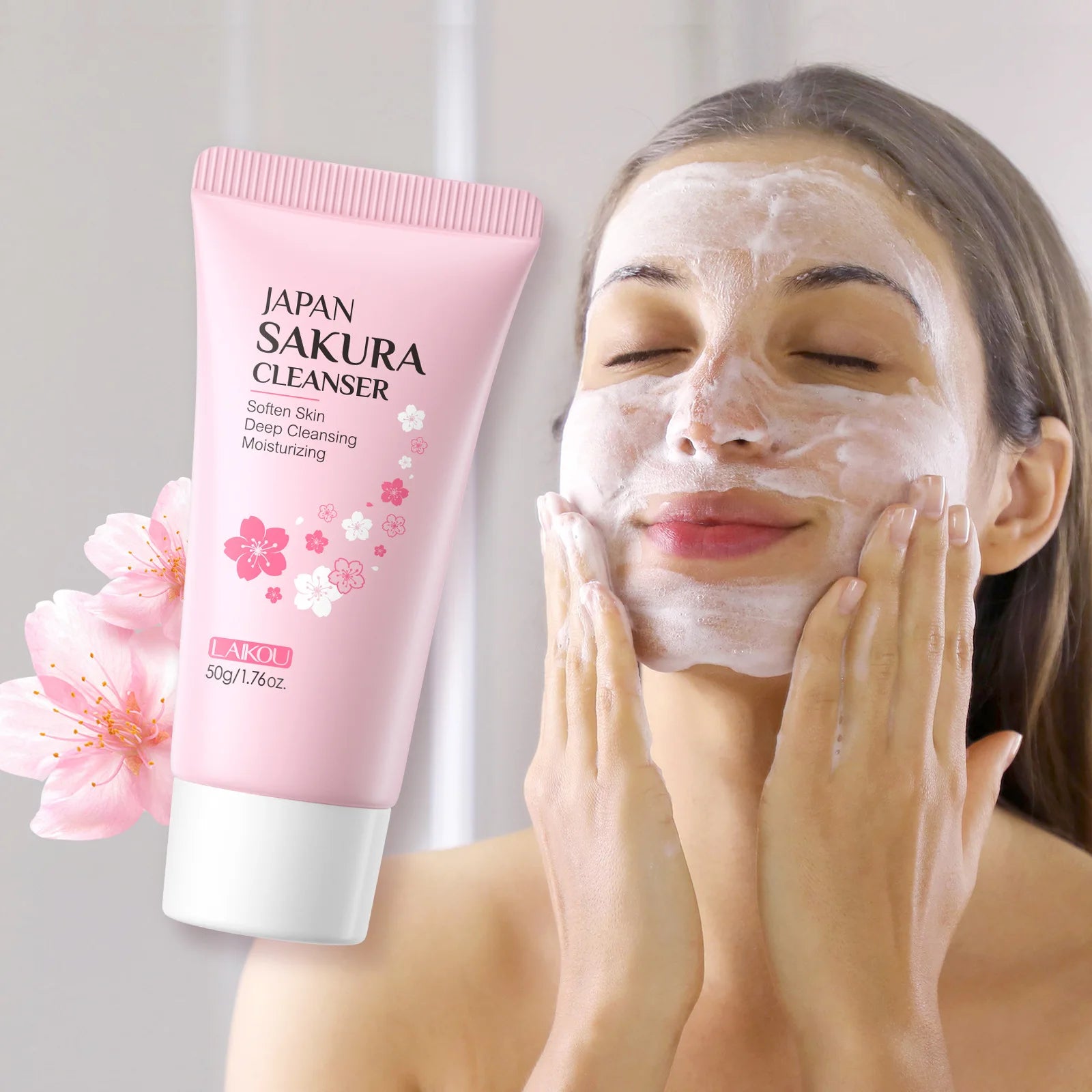Pink Sakura facial cleanser tube, 50g, next to a woman applying white cleansing foam to her face.