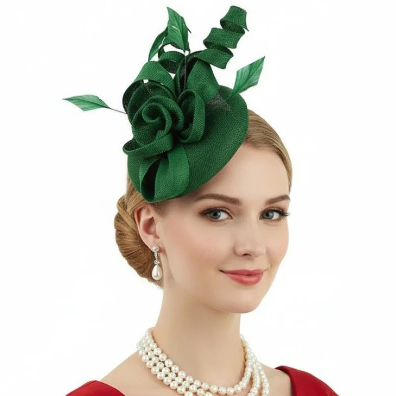 Dark green fascinator hat featuring a large fabric rose, decorative ribbon swirls, and leaf accents on a round base.