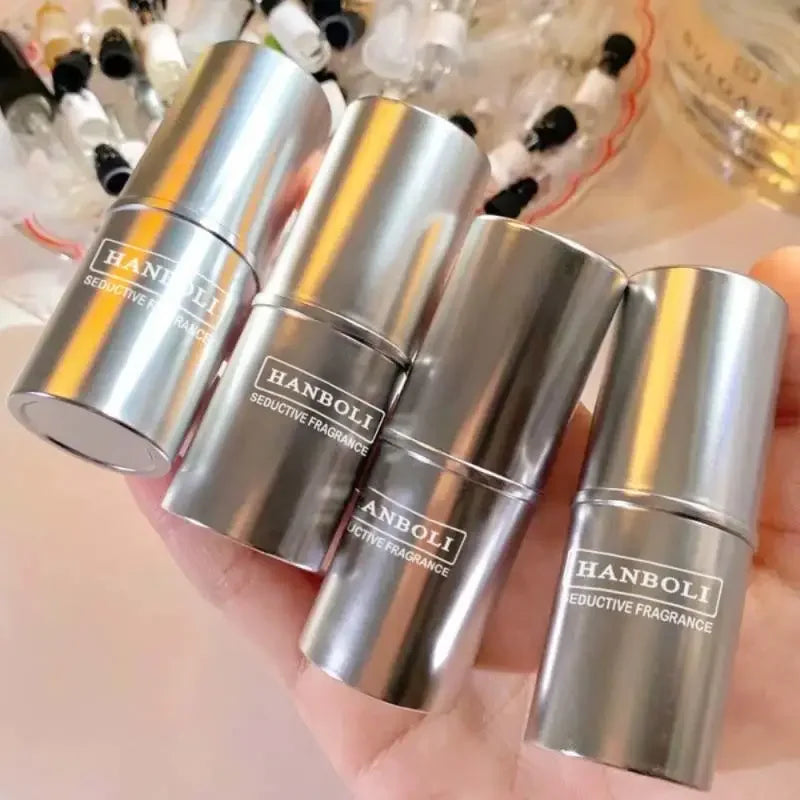 Four silver cylindrical Hanboli perfume oil roll-on bottles held in a hand.