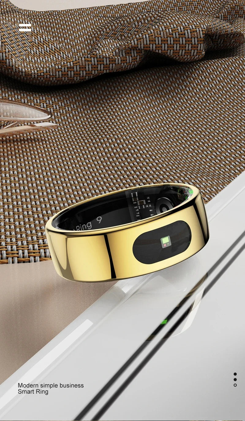 A sleek, polished gold smart health ring with an integrated black sensor display, resting on a reflective surface.