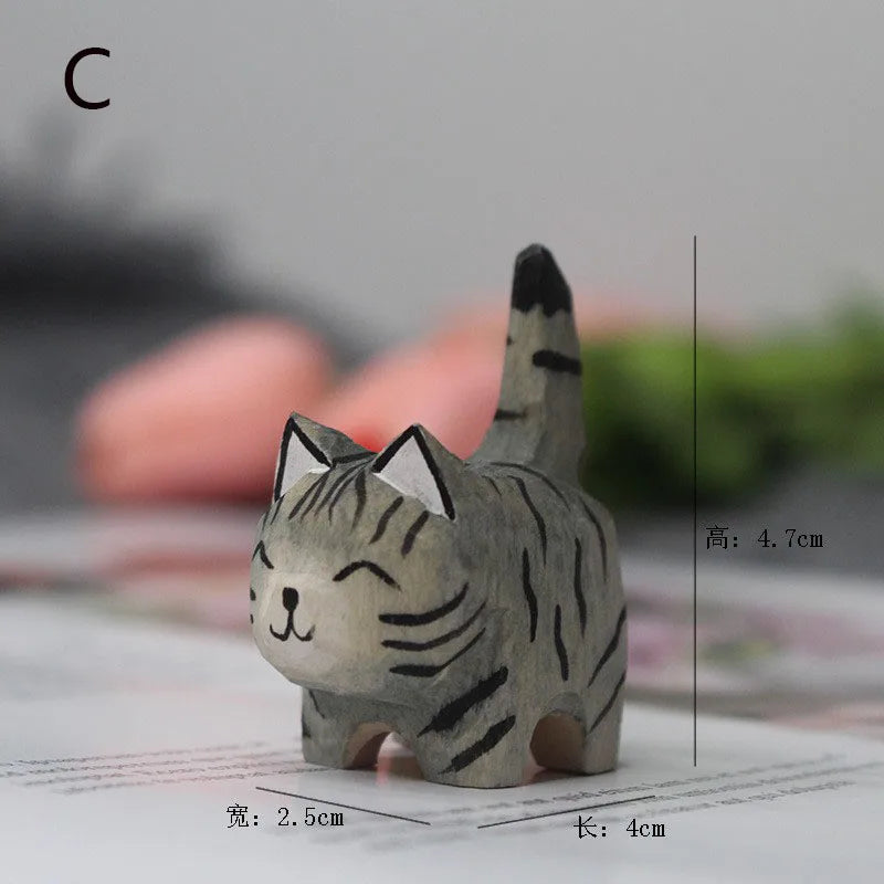 Small, hand-carved wooden grey tabby cat figurine with a smiling expression and upright striped tail.