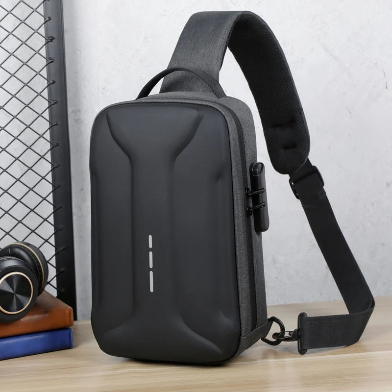 Grey and black anti-theft crossbody bag with a hard-shell front, integrated lock and adjustable shoulder strap.