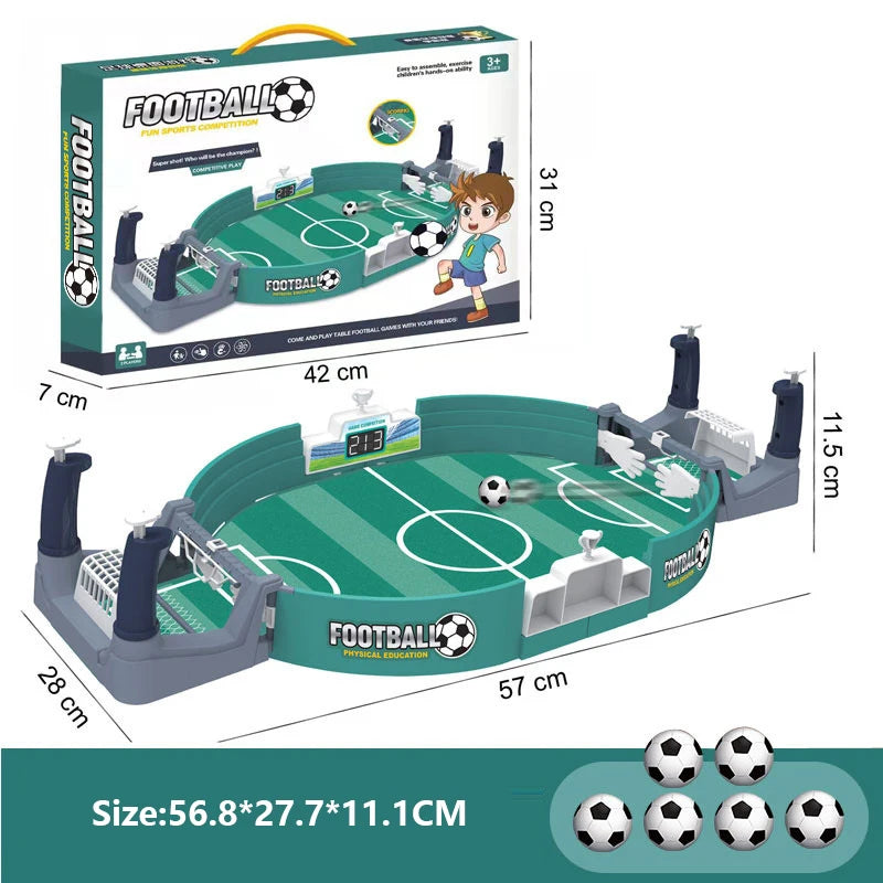 Tabletop football game set with green pitch, two manual controllers, scoreboard, and six small black and white balls.