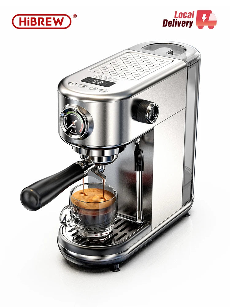 A silver HiBREW espresso machine pours coffee into a clear glass cup on a drip tray, featuring a pressure gauge and display.