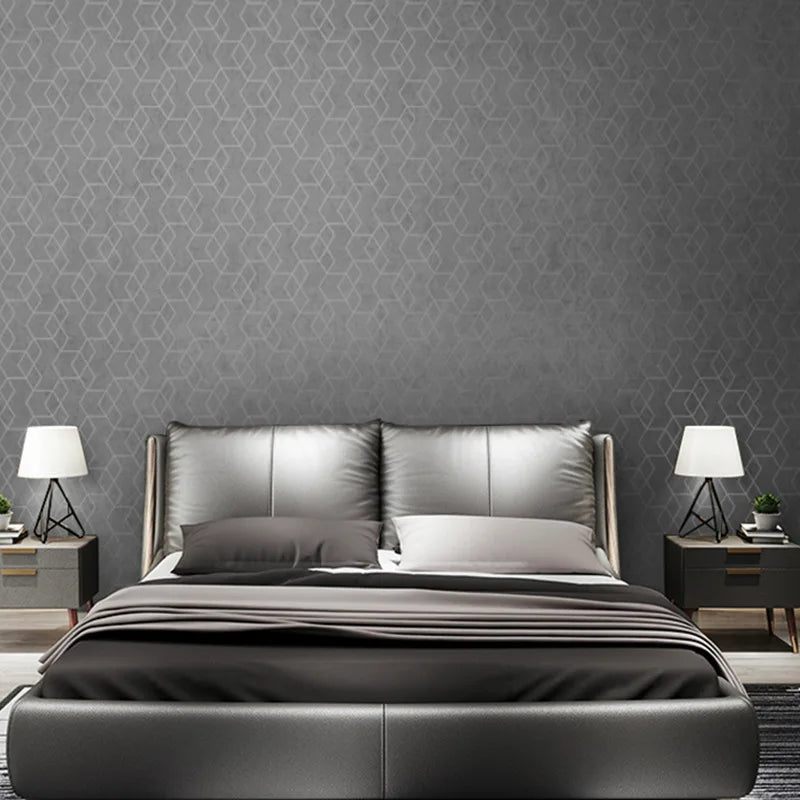 Modern dark grey wallpaper with a subtle geometric hexagon pattern, shown in a contemporary styled bedroom.