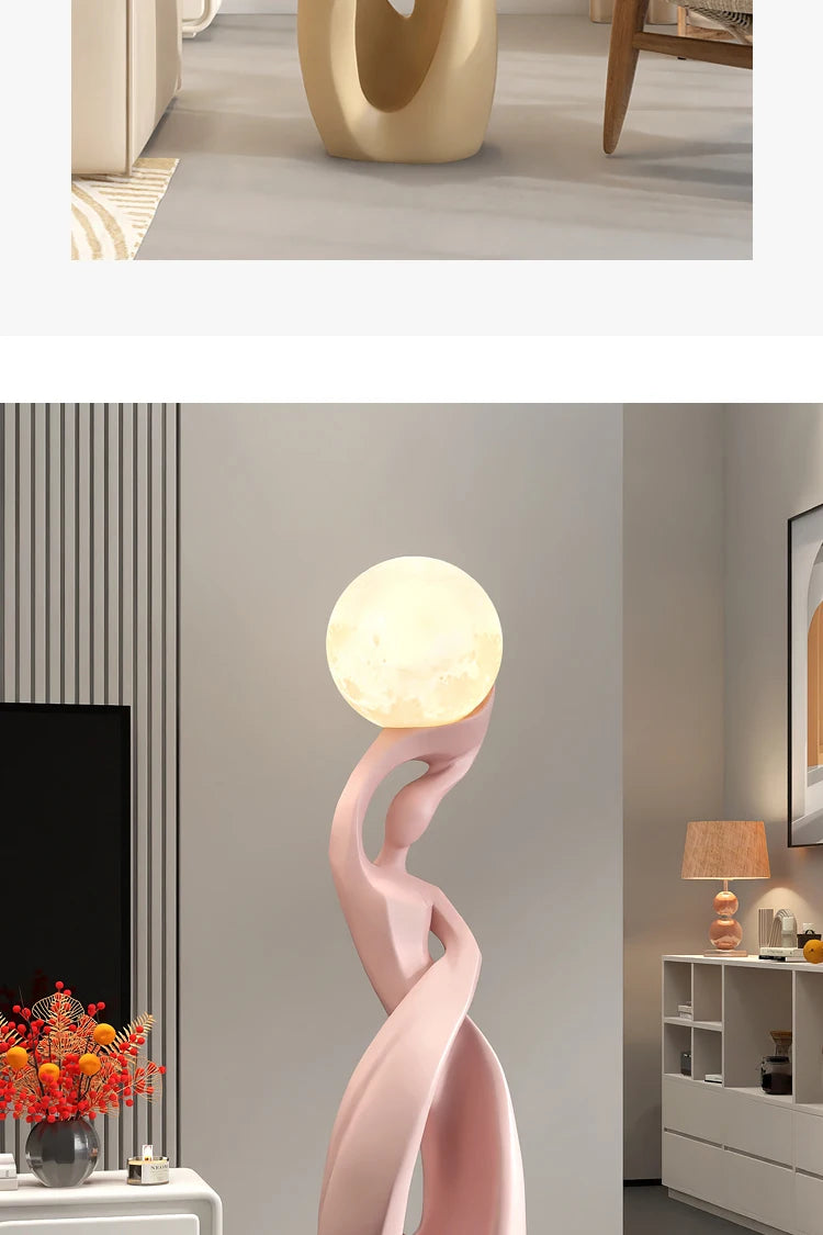 Abstract light-pink resin floor statue of a fluid, dancer-like figure holding an illuminated, glowing moon-style orb.