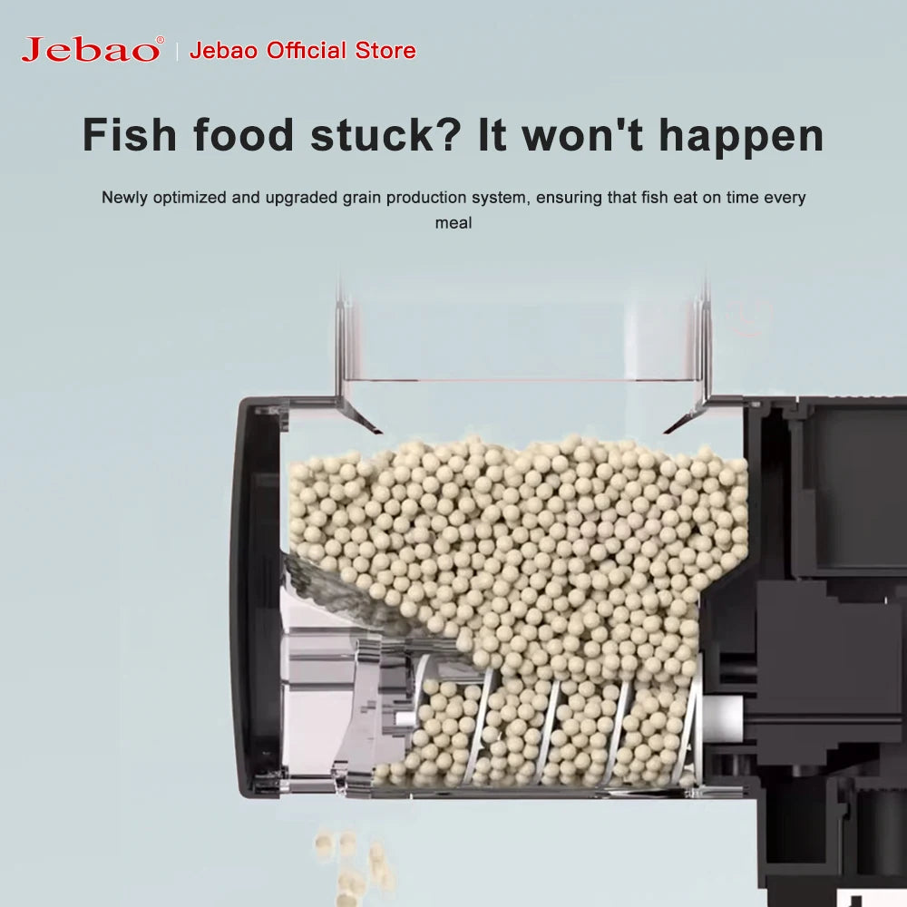 Black automatic fish feeder with a clear reservoir filled with spherical pellets and an internal dispensing auger.