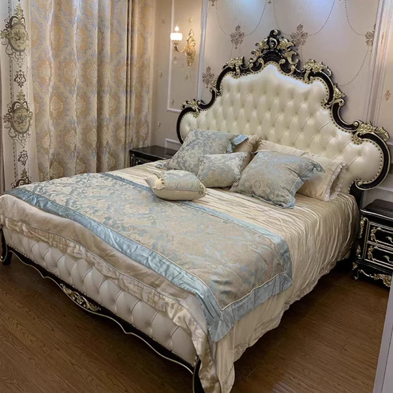 Ornate double bed with a button-tufted cream padded headboard, intricate black and gold trim, and luxury bedding.