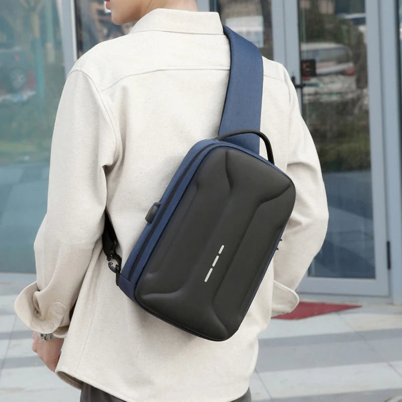 A man wearing a blue and black anti-theft crossbody bag with a built-in USB charging port.