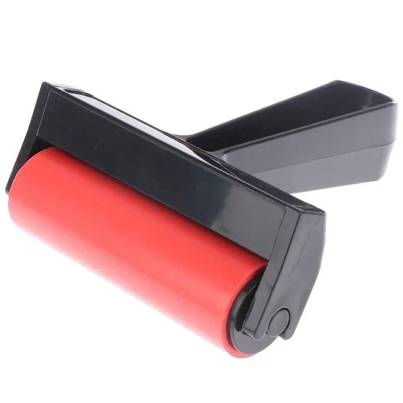 Craft rubber brayer with a vibrant red roller and a sturdy black plastic handle for even ink application.