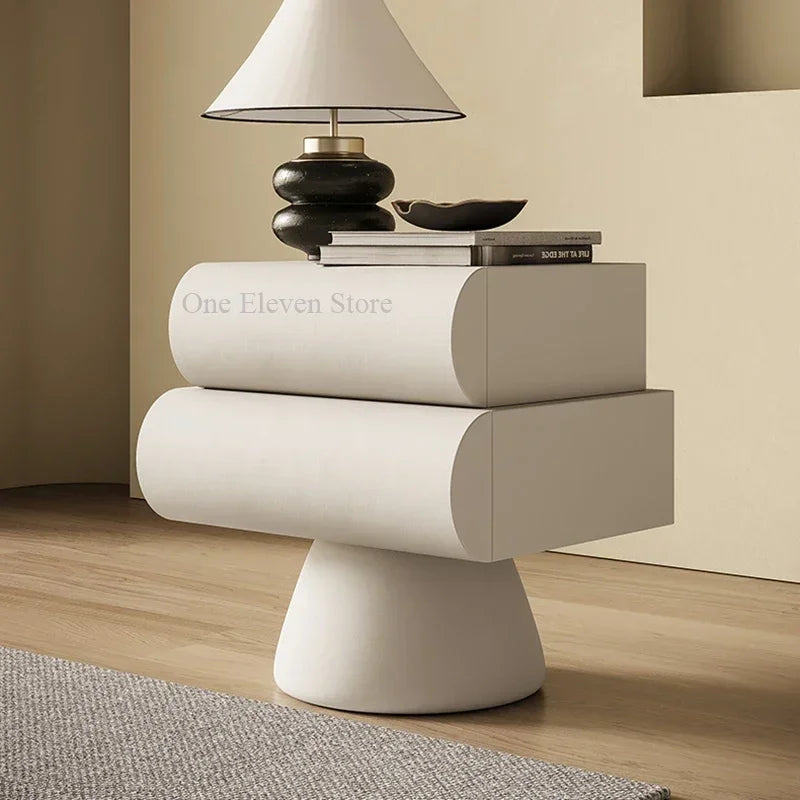 Minimalist matte white bedside table with two rounded drawers on a conical pedestal base.